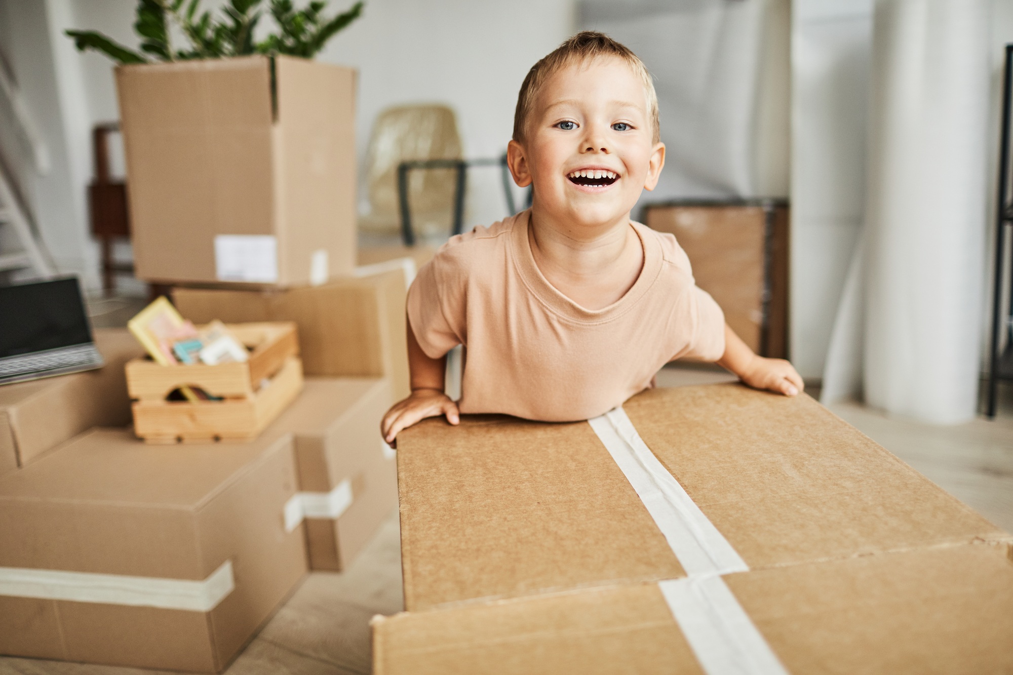 Cute Boy Moving Boxes in New Home